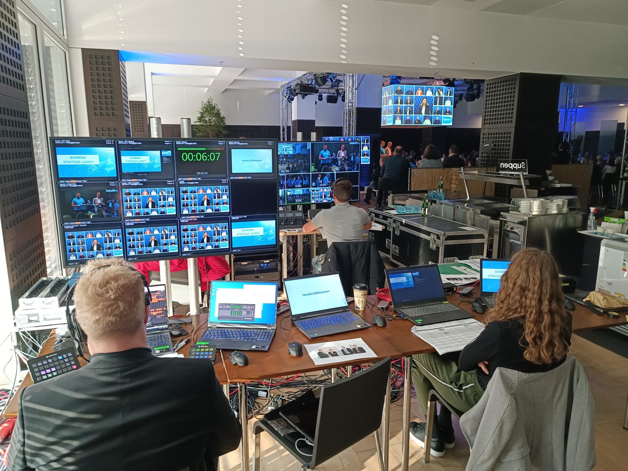 Regieraum oder Technikbereich mit vielen Monitoren und Laptops.