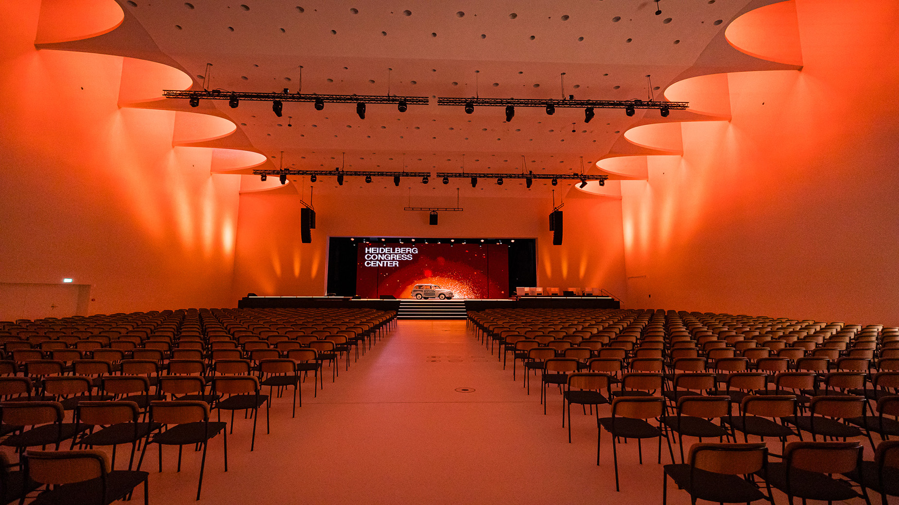 Großer Saal im HCC mit Bühne und Reihenbestuhlung in roter Beleuchtung