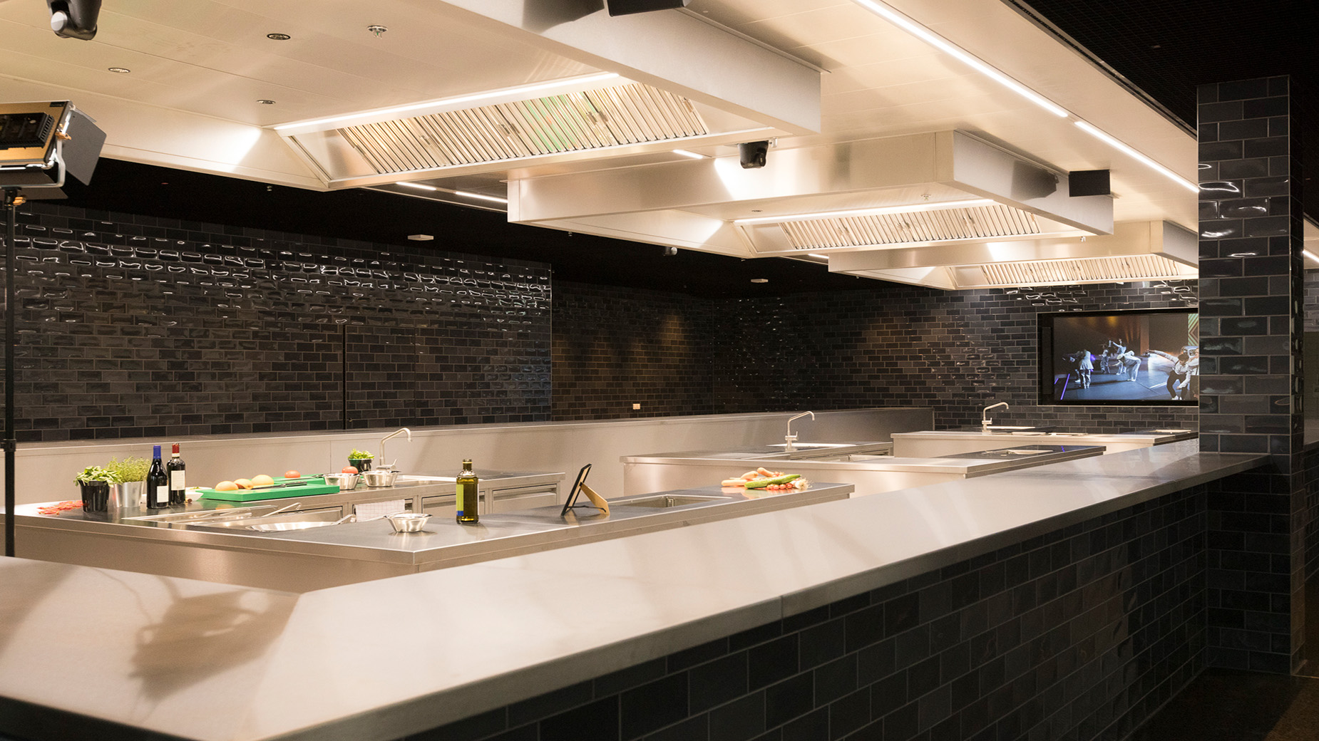 Moderne, stilvoll gestaltete Eventküche im HCC mit dunkler Wandverkleidung, heller Arbeitsfläche und integrierter Beleuchtung. Die Fläche ist für Showcooking oder Catering vorbereitet.