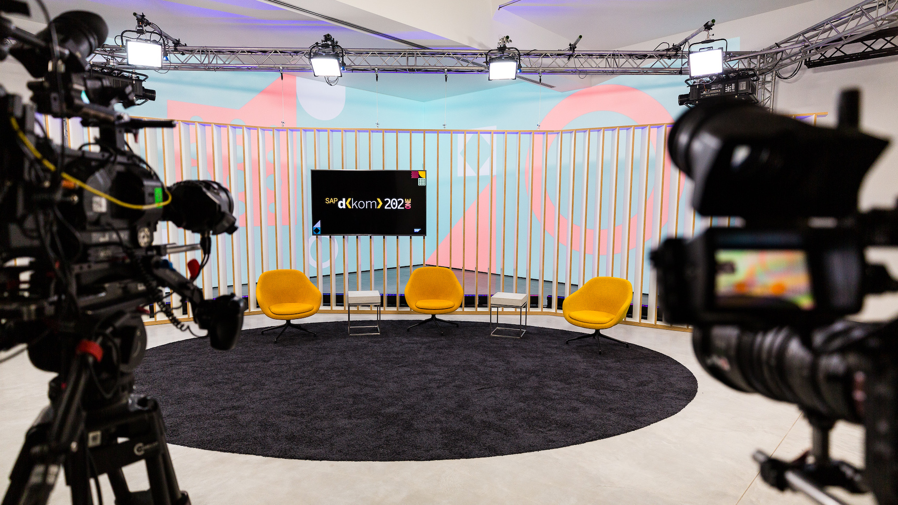 Modernes, leeres TV-Studio mit Kameras im Vordergrund.