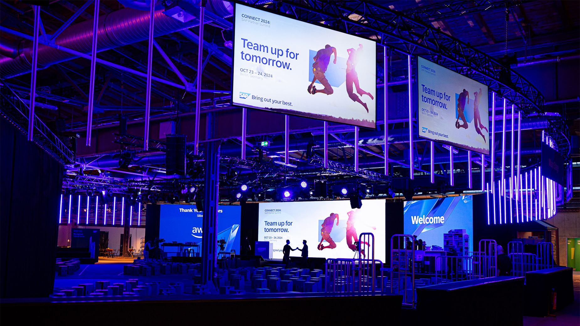 Große Eventbühne mit LED-Wänden und beeindruckender Lichtinstallation in Blau.