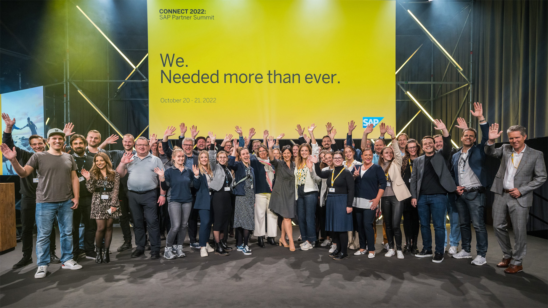 Zu sehen ist das CONNECT Team, das jubelnd auf der großen CONNECT Bühne steht und das gelungene Event feiert.