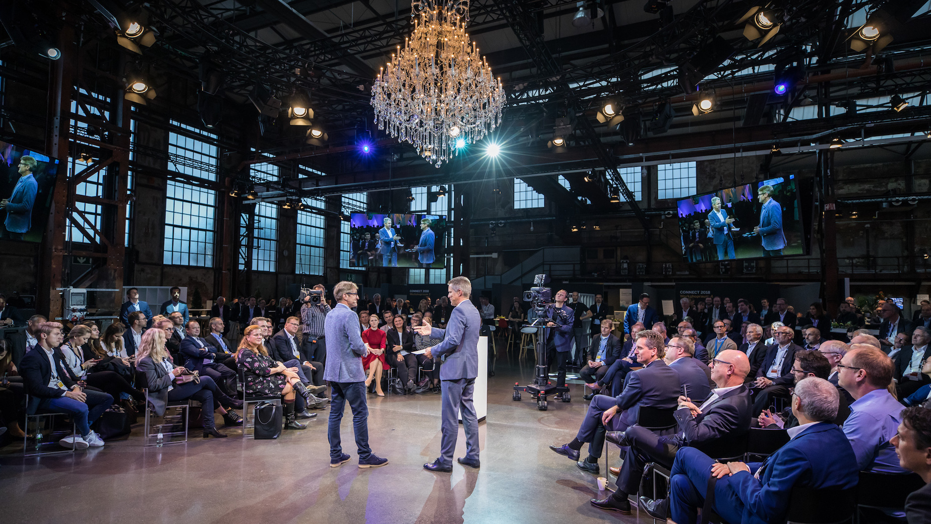 Industriehalle mit Menschen und Kronleuchter