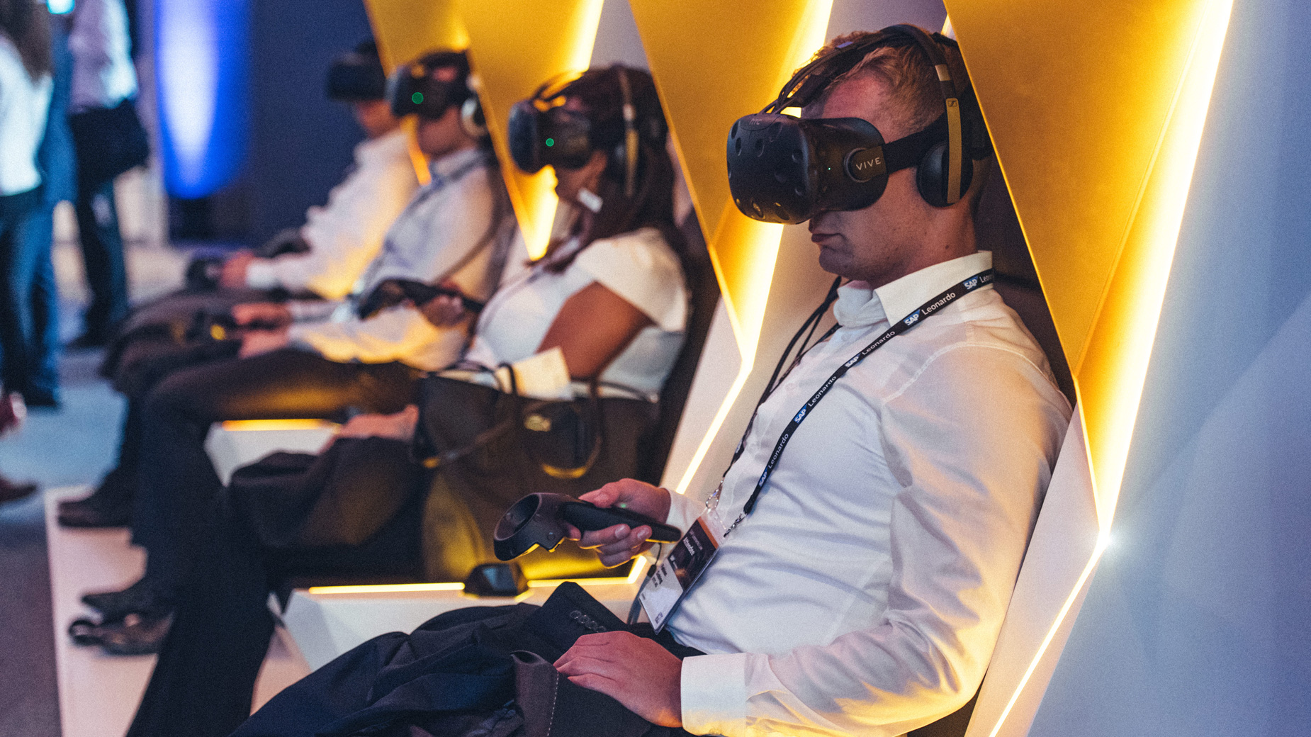 Drei Personen mit VR-Brillen in futuristischen Sesseln bei einer immersiven Erfahrung.