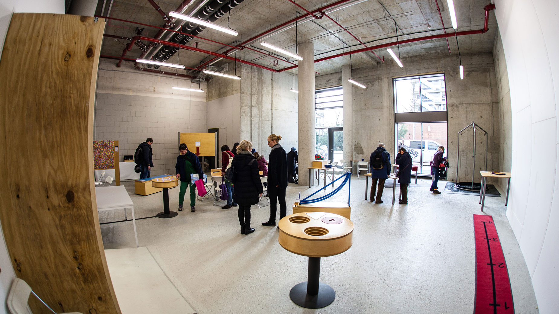 Besucher erkunden moderne Ausstellungsfläche mit interaktiven Stationen im Mathematikon.