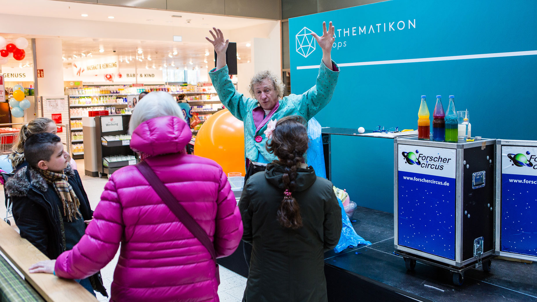 Clown spricht mit Kindern vor der Bühne beim Mathematikon-Event.
