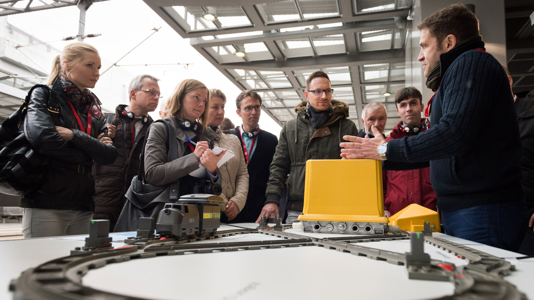 Besuchergruppe erhält eine technische Einführung an einem Modell mit beweglichen Elementen.