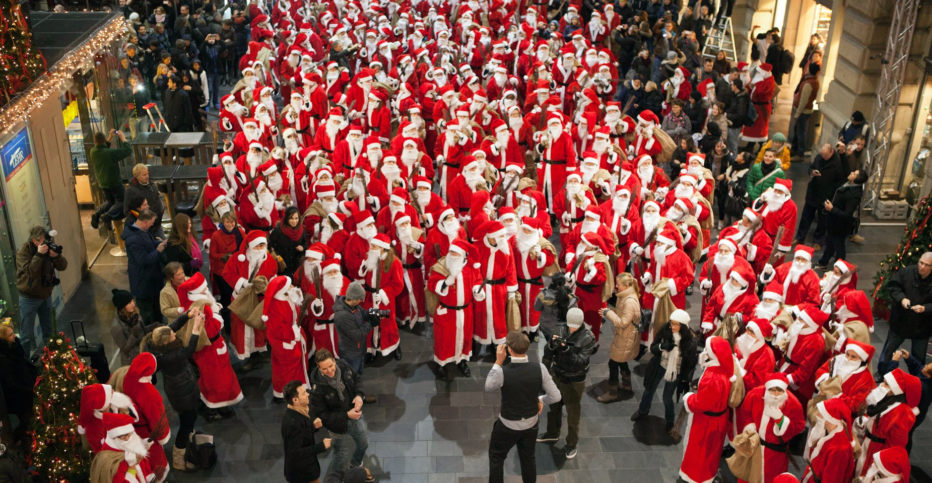 Nikolaus Flashmob: Zahlreiche als Nikolaus verkleidete Menschen singen und tanzen auf dem Bahnsteig des Frankfurter Hauptbahnhofes mit dem Sänger Max Mutzke.