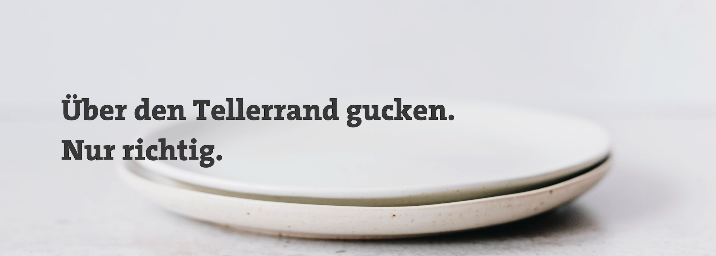 Fotografie eines Tellers. Darauf steht "Über den Tellerrand gucken. Nur richtig".