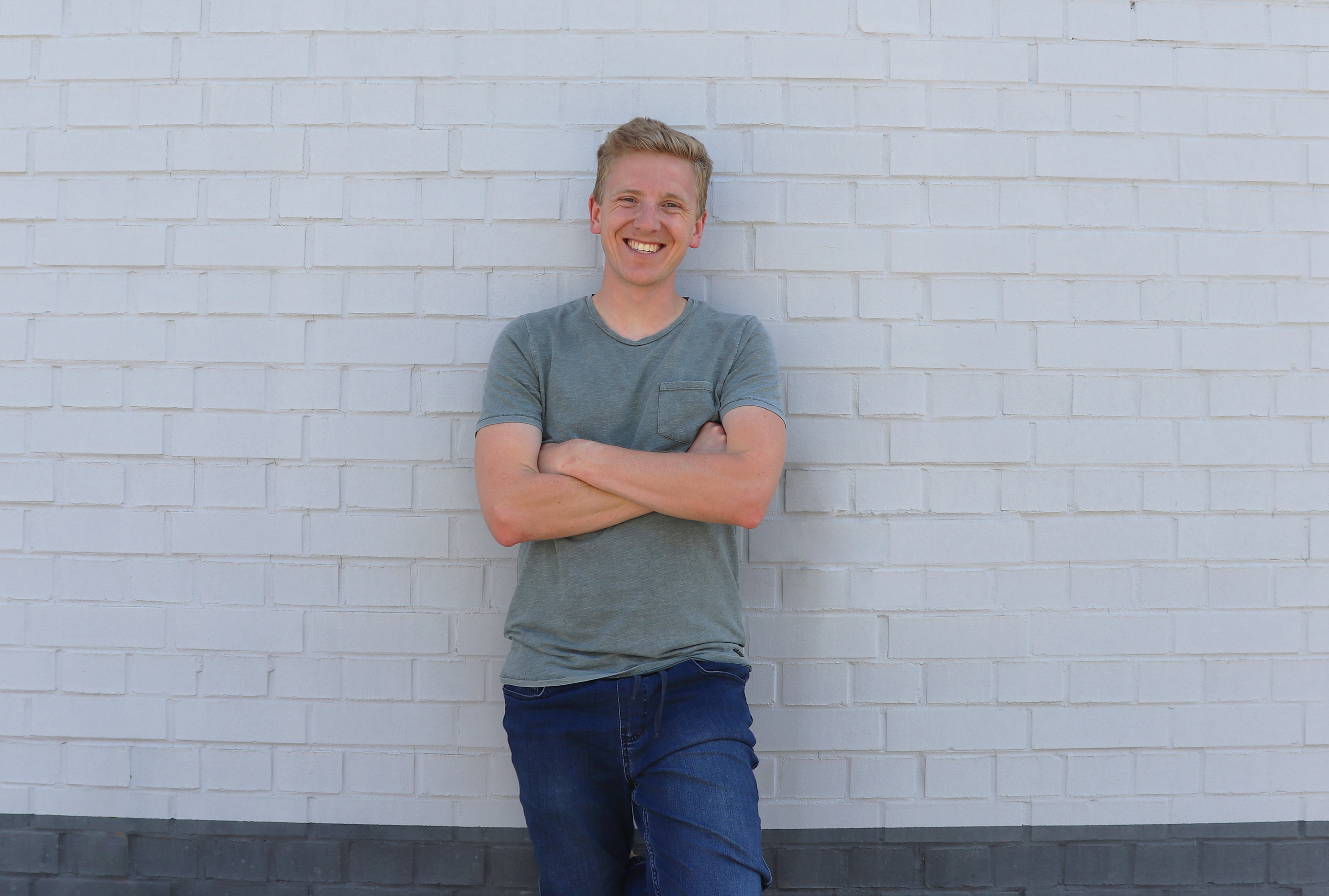 Fotografie von Ole, der vor einer weißen Hauswand steht