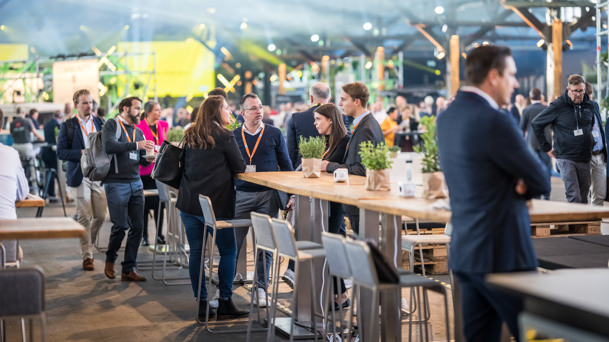Zu sehen ist die Location, in der die Besucher*innen an Stehtischen networken und sich miteinander austauschen.