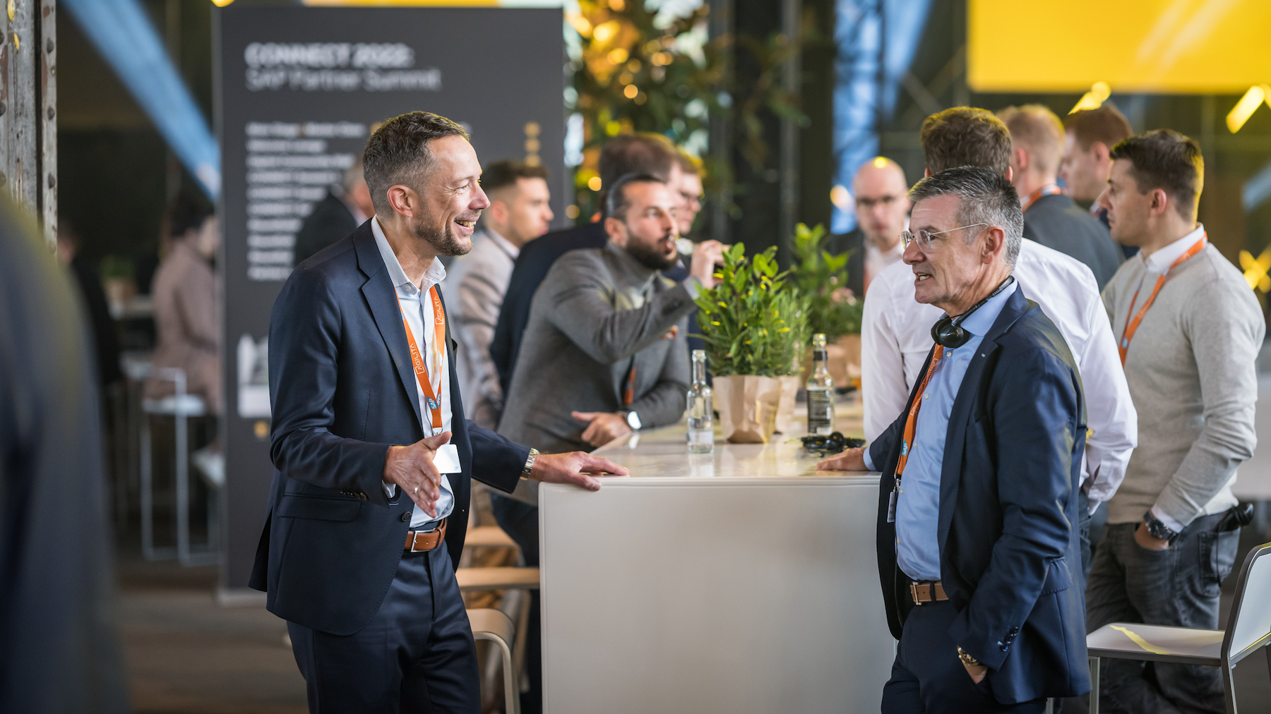 Besucher*innen tauschen sich an den Stehtischen miteinander aus.