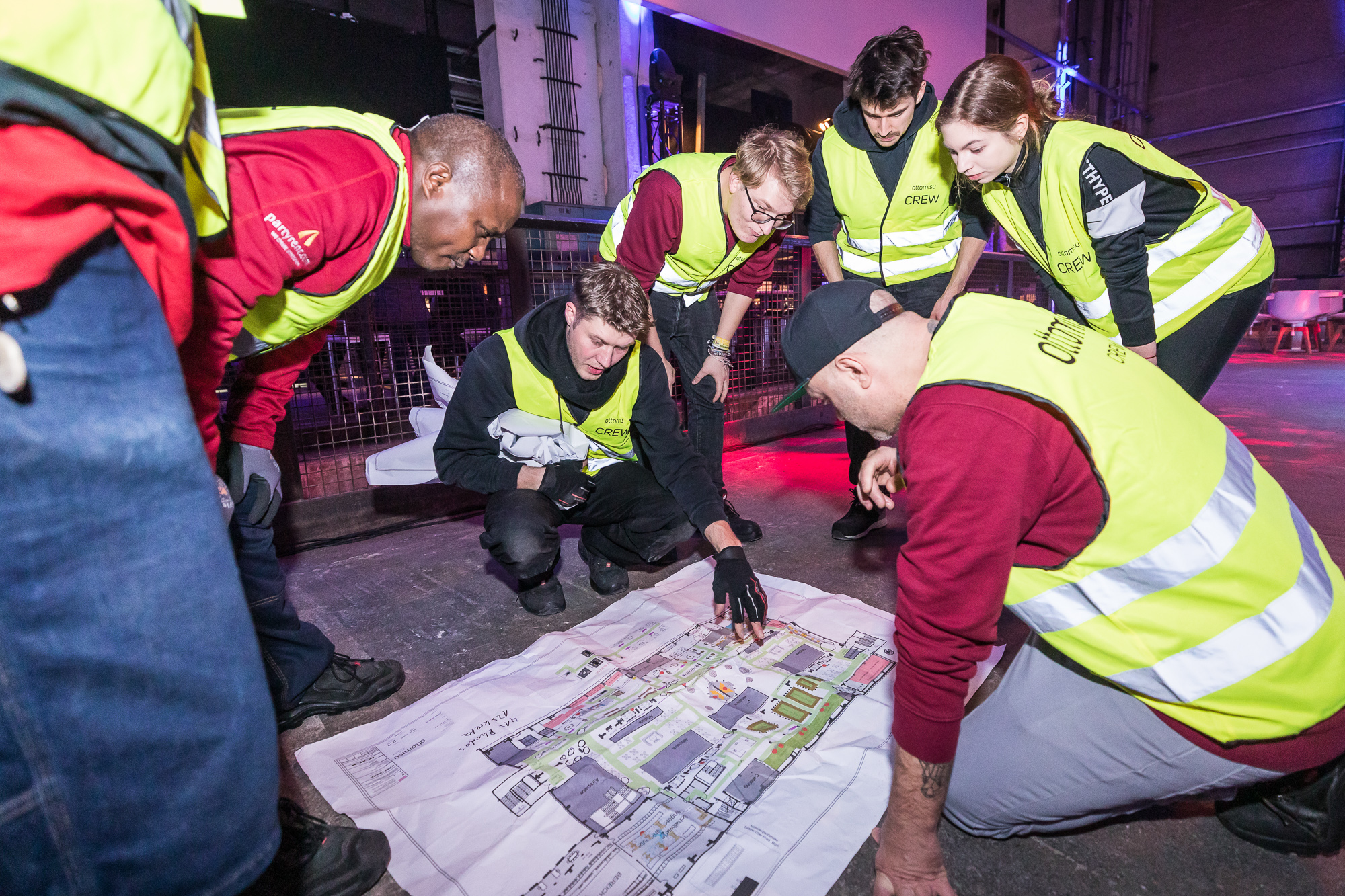 Arbeiter schauen bei Veranstaltungsbau auf einen Lageplan