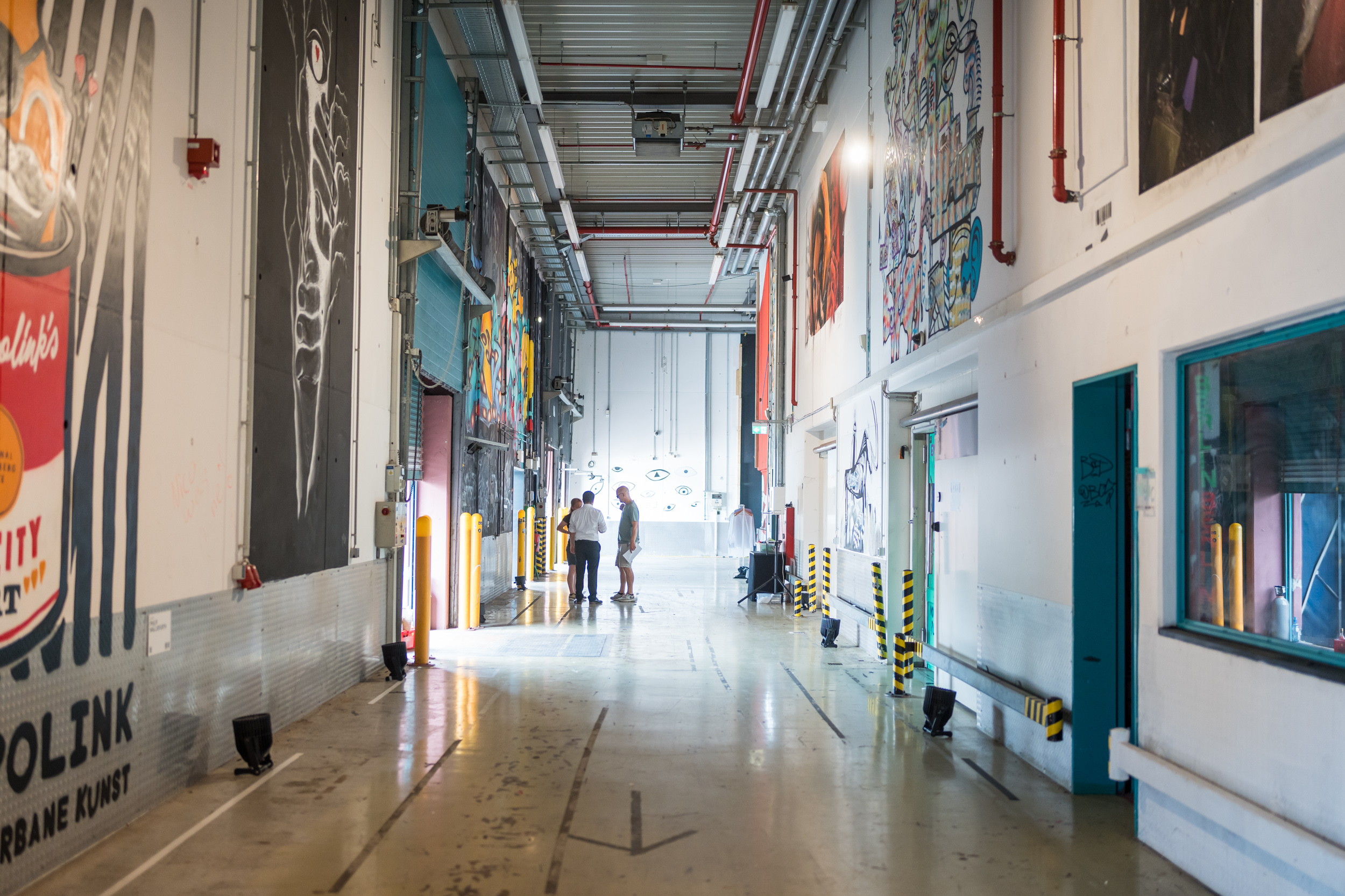 Großer Gang in einer Halle mit vielen bunten Kunstwerken an den Wänden